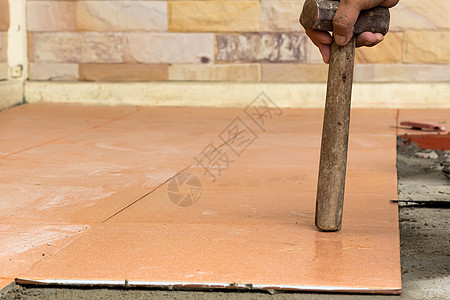 人造建筑工人在家里铺砖加瓦 地板粘合瓷砖研磨装潢石膏工具地面维修修理工职场工作砂浆图片