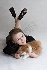 漂亮的女孩拿着一只红小猫猫科动物毛皮女士拥抱成年人微笑房子肩膀女性乐趣图片