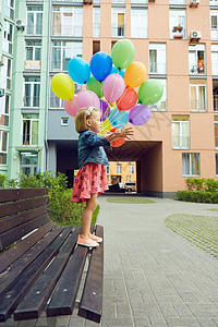 快乐的小女孩户外 有气球童年喜悦生日天空孩子派对婴儿庆典蓝色草地图片