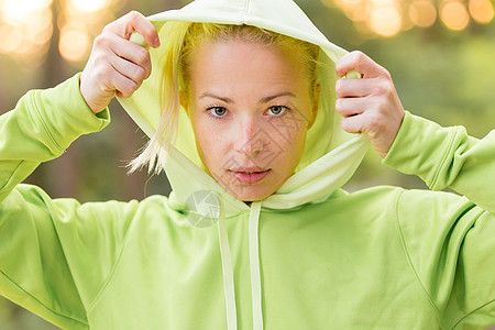 自信的体育女郎穿着时髦的绿色连帽衫兜帽娱乐训练挑战树木女性马尾辫运动成人簇绒图片