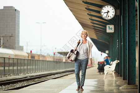 车站时钟女士在火车站等着呢乘客城市民众假期平台旅游手提箱运输过境车站背景