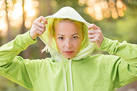 自信的体育女郎穿着时髦的绿色连帽衫跑步训练女性树木娱乐簇绒运动员头发女孩公园图片