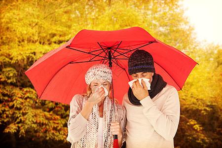 一对生病夫妇站在伞下在组织内打喷嚏的复合图像阳光季节眼睛感染森林披肩橙子疾病发烧衣物图片