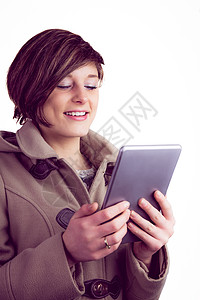 使用平板电脑的有吸引力的女人药片触摸屏滚动冬装休闲服装衣物微笑围巾夹克图片