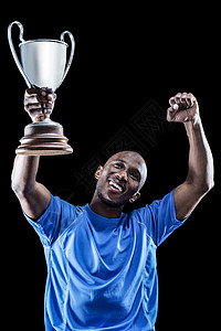 快乐的运动员在握着奖杯时仰望和欢呼图片