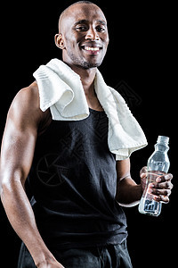 围着颈部拿着瓶子的毛巾而快乐的肌肉人的肖像图片
