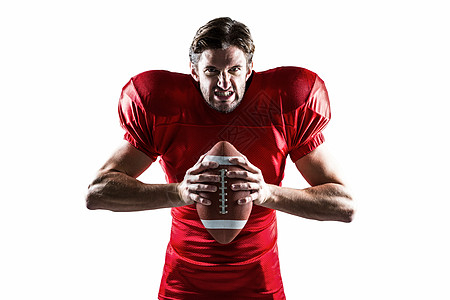 愤怒的美国足球运动员穿红色球衣握着球图片