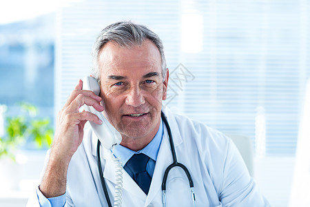 男医生在诊所通过电话交谈图片