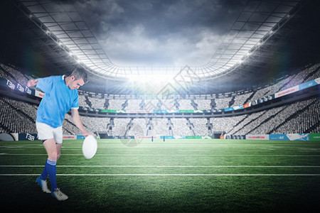 橄榄球运动员踢橄榄球的复合图象专注球衣男性运动绿色男人竞技场竞赛沥青播放器图片