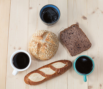热咖啡杯和木制桌上的面包粮食包子面粉杯子豆子咖啡早餐棕色饮食小麦图片