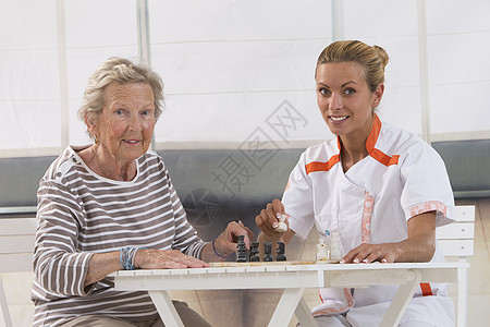 在养老院与护士一起玩的高级妇女老年障碍居家女士护理草地退休荒地居民帮助图片