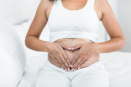 孕妇在肚子上做心脏记号母亲享受女性白色双手女士生活情感怀孕腹部图片