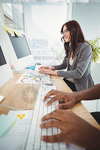 与商业妇女一起在计算机服务台键盘键盘上打字图片