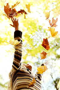 女人在秋天落叶女孩乐趣微笑享受叶子黄色女士投掷喜悦幸福图片
