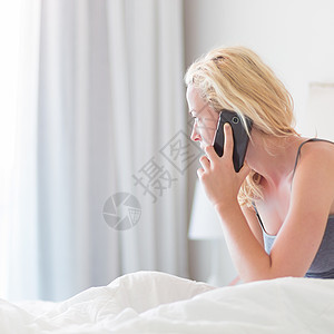 女人早上在床上通过电话聊天枕头闲暇汽车手机细胞女儿讲话商业客人女孩图片