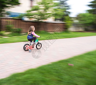 儿童乘自行车快速骑车 与投星者一起活动童年孩子自由幸福女孩训练快乐情感车轮图片