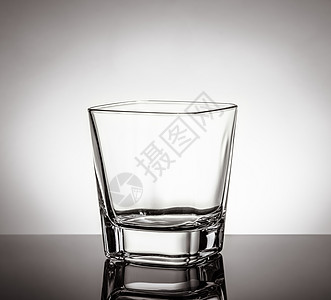 黑桌上空威士忌杯子 白底面反射镜像图片
