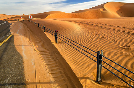 一条穿越沙漠沙丘的道路黄色干旱旅行晴天旅游太阳绿洲图片