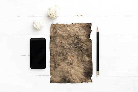 燃烧的棕色纸和带智能电话的折叠纸商业白色记事本床单笔记本文档笔记挫折办公室创造力图片