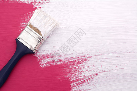 粉红色上涂有白油漆的画笔图片