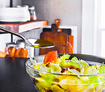 在意大利新鲜沙拉上加橄榄油的勺子 在木制厨房上加橄榄油和番茄烹饪蔬菜香料餐厅小吃果汁饮食美食叶子营养图片