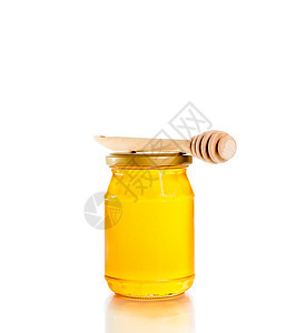 白色背景的蜂蜜罐 配有木制蜂蜜图片