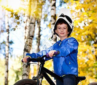 男孩骑自行车公园乐趣孩子行动骑术活动季节森林闲暇学校图片