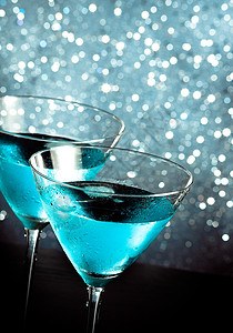 一杯新鲜的蓝色鸡尾酒 桌边有冰块图片