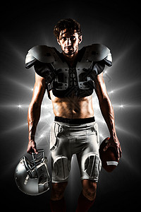 美式足球运动员身着球和头盔的甲板搭接球和头盔综合图象男人运动竞赛红色竞技灰色专注运动服聚光灯体育图片