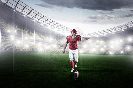 美式足球运动员踢足球的合成图像聚光灯沥青体育场足球场竞技竞技场体育男人运动服持有者图片