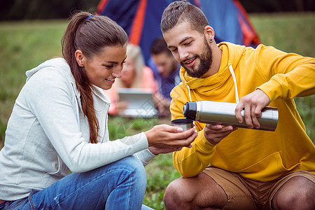 玩得开心的朋友在野营之旅农村闲暇娱乐活动帐篷女士热饮环境夫妻热水瓶图片