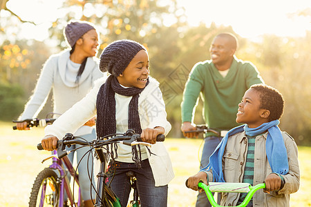年轻 笑着微笑的家庭骑自行车环境骑术乐趣女孩活动幸福父亲男人闲暇母亲图片