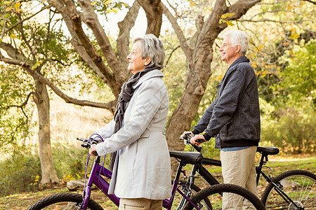 公园里的老夫妇绿地微笑开襟衫夫妻男人娱乐自行车快乐环境衣物图片