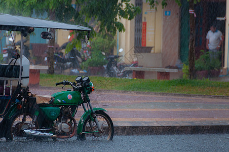 水墨雨Tuktuk 在贡布的雨季风中进行自动循环运输出租车天气下雨街道摩托车摩托人力车背景