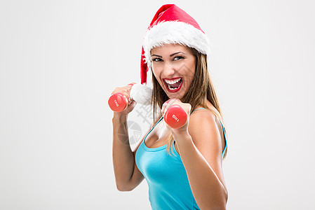 圣诞节健身妇女新年幸福节食微笑乐趣训练运动水平服装哑铃背景图片