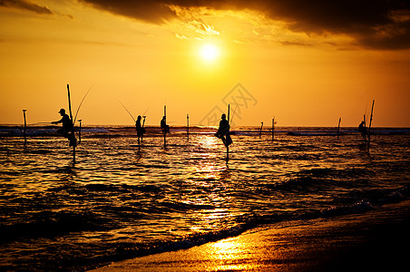 日落之夜传统矮渔夫的休眠轮椅日落天空平衡钓鱼耐力高跷男性鱼人男人文化图片