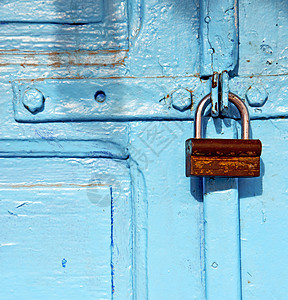蓝色木制门中被剥除的涂料安全挂锁保障黄铜木头隐私钥匙锁孔铰链入口图片