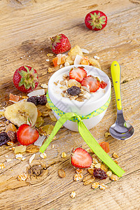 配有谷类穆埃斯里和新鲜草莓的酸奶水果食物粮食木头玻璃营养早餐勺子燕麦金属图片