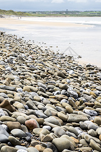 高尔夫球场旁的沙滩支撑地平线石头蓝色卵石旅行场景海岸海岸线海洋图片