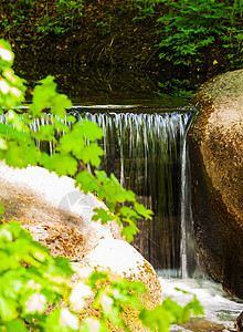 瀑布飘流在石頭上旅行石头太阳假期树木公园森林场景阳光季节背景图片
