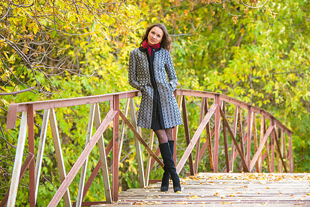 站在桥上的女人有个年轻女孩站在温暖秋天的桥上背景