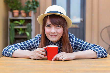 穿着帽子的女士坐在户外 喝热饮放松咖啡咖啡店女性女孩巧克力杯子饮料食物享受黑发图片