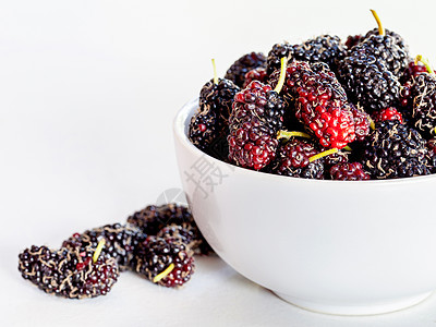白色背景的碗里叶子上的新鲜有机木莓桌子团体植物农业健康紫色饮食市场水果收藏图片