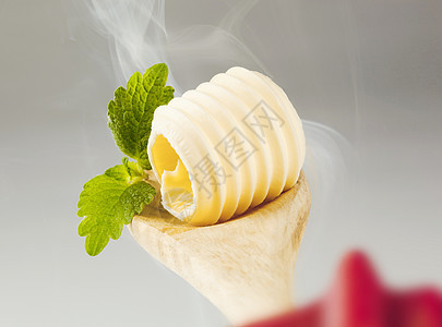 木勺上的黄油卷子食物厨房蒸汽卷曲用具食品烹饪奶制品勺子图片
