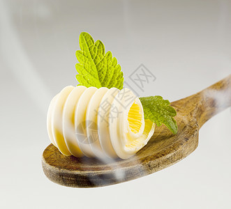 木勺上的黄油卷子蒸汽奶制品食品厨房用具卷曲烹饪勺子食物图片