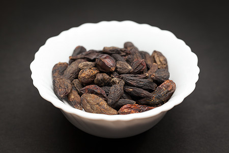 陶瓷碗里的有机润滑油米洛巴兰化学玻璃香料草药调味品水果制品黑色诃子种子图片