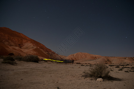 在夜间沙漠中徒步旅行旅游爬坡吸引力星星远足天空冒险游客图片