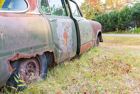 废弃的旧车在草地中腐烂图片