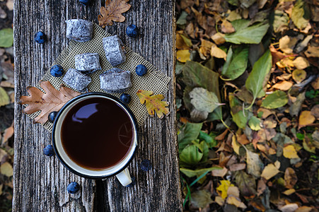 浪漫的秋天静止的生命树叶选择性季节冷色调甜点篮子糕点浆果饼干茶杯背景图片