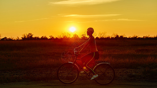 日落时的比克女孩场地天空女性女士太阳假期女孩车轮骑术农村图片
